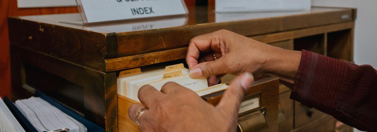 hands flipping through index cards at the archives