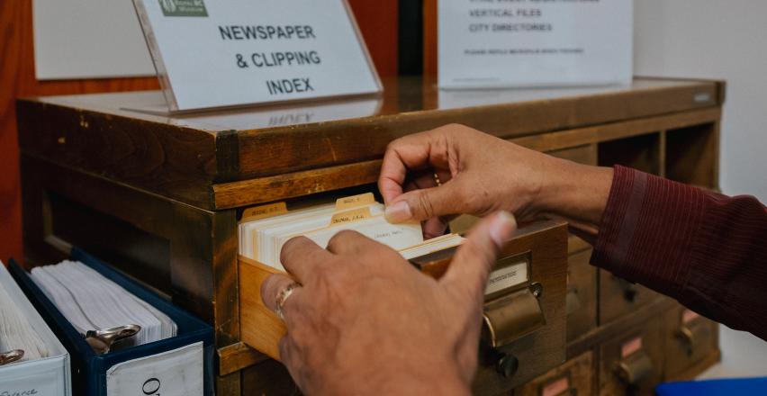 hands flipping through index cards at the archives