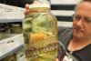 a man holds a jar with a snake specimen inside